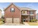 Beautiful brick two-story home with a stone entryway, two-car garage, landscaped yard, and an American flag on display at 4560 Evandale Way, Cumming, GA 30040