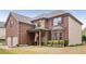 Attractive two-story brick home features a manicured lawn, complemented by shrubbery and a welcoming front porch at 4560 Evandale Way, Cumming, GA 30040