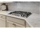 Close-up of a cooktop in a gourmet kitchen with granite counters and stylish backsplash at 4560 Evandale Way, Cumming, GA 30040