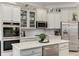 Modern kitchen featuring white cabinets, stainless steel appliances, a center island with quartz countertops, and stylish backsplash at 4560 Evandale Way, Cumming, GA 30040