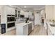 Bright kitchen featuring white cabinets, stainless steel appliances, a center island, and easy access to the pantry at 4560 Evandale Way, Cumming, GA 30040