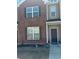 Charming townhouse featuring brick facade and neutral siding with a small front lawn area at 6311 Olmadison Pl, Atlanta, GA 30349