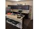 Open kitchen features dark cabinets, stainless appliances, and breakfast bar with seating for four at 6311 Olmadison Pl, Atlanta, GA 30349
