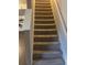 Carpeted staircase with handrail and neutral walls connecting levels at 6311 Olmadison Pl, Atlanta, GA 30349