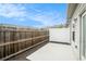 Backyard with a concrete slab patio bordered by a wood and white fence and mulch bed at 7701 Haynes Park Pl, Lithonia, GA 30038