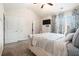 Bright bedroom showcasing a tufted headboard bed, white dresser with TV, and window with patterned curtains at 7701 Haynes Park Pl, Lithonia, GA 30038