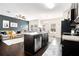 Stylish open-concept kitchen with stainless appliances, granite countertops, and a view of the living room at 7701 Haynes Park Pl, Lithonia, GA 30038