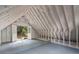 Unfinished attic space with painted white walls, wooden beams and access to the outside at 1503 Emory Ne Rd, Atlanta, GA 30306