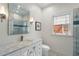 Bathroom with modern vanity, marble countertop, decorative mirror, and tiled shower at 1503 Emory Ne Rd, Atlanta, GA 30306
