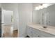 Bright bathroom featuring a white vanity, a large mirror, and hardwood floors leading to another room at 1503 Emory Ne Rd, Atlanta, GA 30306