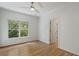 Cozy bedroom with a ceiling fan, large window offering abundant natural light, and hardwood floors at 1503 Emory Ne Rd, Atlanta, GA 30306