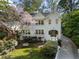 Charming white brick home with blooming tree, bench, and inviting curb appeal at 1503 Emory Ne Rd, Atlanta, GA 30306