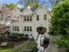 Charming white brick home with blooming tree, bench, and inviting curb appeal at 1503 Emory Ne Rd, Atlanta, GA 30306