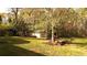Home backyard featuring a shed, mature trees, and a lush green lawn at 1718 Pucketts Sw Dr, Lilburn, GA 30047