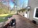 Backyard view of a raised wooden deck attached to the home with green grass at 1718 Pucketts Sw Dr, Lilburn, GA 30047