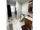 Modest bathroom with white tile floors, a toilet, vanity, and window, creating a functional space at 1718 Pucketts Sw Dr, Lilburn, GA 30047