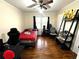 Bedroom with hardwood floors, ceiling fan, window with black curtains, and shelving at 1718 Pucketts Sw Dr, Lilburn, GA 30047