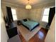 Cozy bedroom with hardwood floors, neutral walls, and large windows with black curtains at 1718 Pucketts Sw Dr, Lilburn, GA 30047
