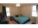 Cozy bedroom featuring hardwood floors, two windows providing natural light, and a comfortable bed with soft bedding at 1718 Pucketts Sw Dr, Lilburn, GA 30047