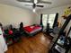 Bedroom with ceiling fan, hardwood floors, speakers, and a window with black curtains at 1718 Pucketts Sw Dr, Lilburn, GA 30047
