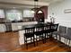 Bright kitchen features an island with barstool seating, white cabinets, and unique brick detail around stove at 1718 Pucketts Sw Dr, Lilburn, GA 30047