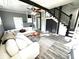 Bright living room featuring sleek, gray-tone wood flooring, ceiling fan, and comfortable sectional couch at 1718 Pucketts Sw Dr, Lilburn, GA 30047