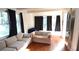 Cozy living room with hardwood floors, a neutral sofa, and large windows with black curtains at 1718 Pucketts Sw Dr, Lilburn, GA 30047
