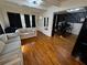 Bright living room features beautiful wood floors, neutral sofa, and black accents throughout at 1718 Pucketts Sw Dr, Lilburn, GA 30047