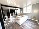Sunlit living room with gray walls, beamed ceilings, modern shelving, and sleek wood laminate flooring at 1718 Pucketts Sw Dr, Lilburn, GA 30047