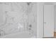 Elegant bathroom with marble-look tiled walls, a tub and shower combination, and a modern, bright design at 3406 Randell Brown Avenue Unit 3, Atlanta, GA 30354