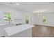 Well-lit open kitchen with a center island, white cabinets, stainless steel appliances, and a view into the dining area at 3406 Randell Brown Avenue Unit 3, Atlanta, GA 30354