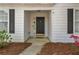 Home front entrance with black door, white siding, black shutters, and small front garden at 5882 Riverside Walk Dr, Sugar Hill, GA 30518