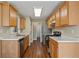 Galley kitchen with stainless steel appliances and light wood cabinets at 5882 Riverside Walk Dr, Sugar Hill, GA 30518