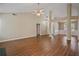Spacious living room featuring hardwood floors, neutral walls, a ceiling fan, and multiple entryways at 5882 Riverside Walk Dr, Sugar Hill, GA 30518
