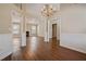 Spacious living room and dining room featuring hardwood floors, neutral walls, a chandelier, and multiple entryways at 5882 Riverside Walk Dr, Sugar Hill, GA 30518
