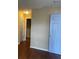 Hallway with wood flooring leading to a bathroom, and a partially visible door at 6113 Princeton Ave, Morrow, GA 30260
