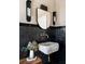 Unique bathroom featuring black tiled walls, stone sink, and modern sconces offering a contemporary design at 1311 Berwick Ne Ave, Atlanta, GA 30306