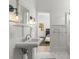 Elegant bathroom with a pedestal sink, marble floors, and view to the adjacent bedroom, offers a soothing design at 1311 Berwick Ne Ave, Atlanta, GA 30306