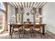 Well-lit dining room with exposed beam ceilings and large pendant lights over a wooden table at 1311 Berwick Ne Ave, Atlanta, GA 30306