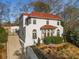 Attractive two-story home featuring a terracotta roof, arched windows, and a long driveway leading to a detached garage at 1311 Berwick Ne Ave, Atlanta, GA 30306