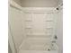 Clean, white bathroom features a shower-tub combo with shelving and modern fixtures at 1968 Copperfield Cir, Decatur, GA 30035