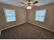 Bright bedroom with two windows, neutral walls, ceiling fan, and new carpet at 1968 Copperfield Cir, Decatur, GA 30035