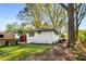 Large backyard with putting green, white brick building, and seating area at 2322 Poplar Springs Ne Dr, Brookhaven, GA 30319