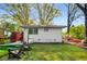 Landscaped backyard with lush lawn, lounge chairs, and charming white brick building at 2322 Poplar Springs Ne Dr, Brookhaven, GA 30319