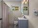 Bright bathroom with a blue vanity, modern fixtures, and a window providing natural light and ventilation at 2322 Poplar Springs Ne Dr, Brookhaven, GA 30319