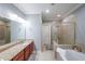 Bright bathroom featuring double vanity, granite countertops, glass shower, and soaking tub at 402 River Vista Dr, Atlanta, GA 30339