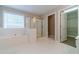 Bright bathroom with white tile, soaking tub, and glass-enclosed shower and view to walk-in closet at 1170 Livery Cir, Lawrenceville, GA 30046