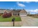 Charming brick home with well-manicured lawn, long driveway and a two-car garage, set against a blue sky at 1170 Livery Cir, Lawrenceville, GA 30046