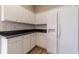 Kitchen with white cabinets, black countertops, white tile backsplash and wood flooring at 1170 Livery Cir, Lawrenceville, GA 30046