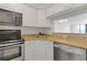 Compact kitchen with stainless steel appliances and granite countertops at 2870 Pharr Court South Nw # 1209, Atlanta, GA 30305